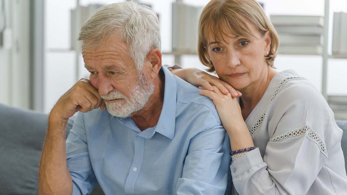 Ein älterer Mann und eine ältere Frau blicken besorgt. 